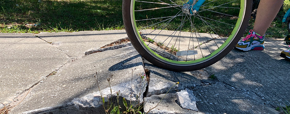 broken sidewalk is a danger to cyclists