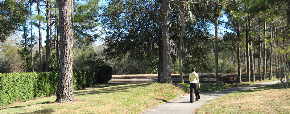 woman walking on wooded, manicured path