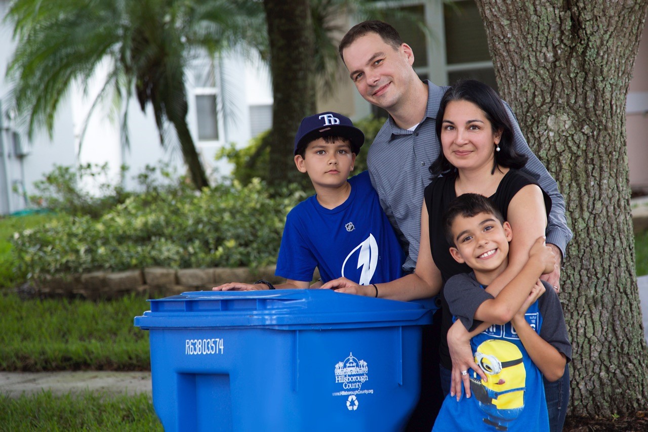 Family posing with waste bins