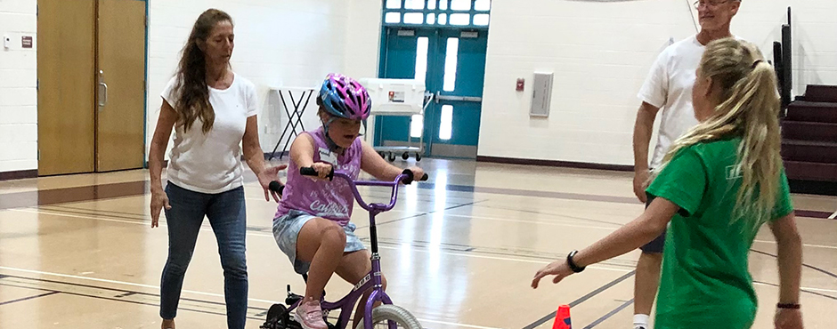 disabled child being taught how to ride a bike